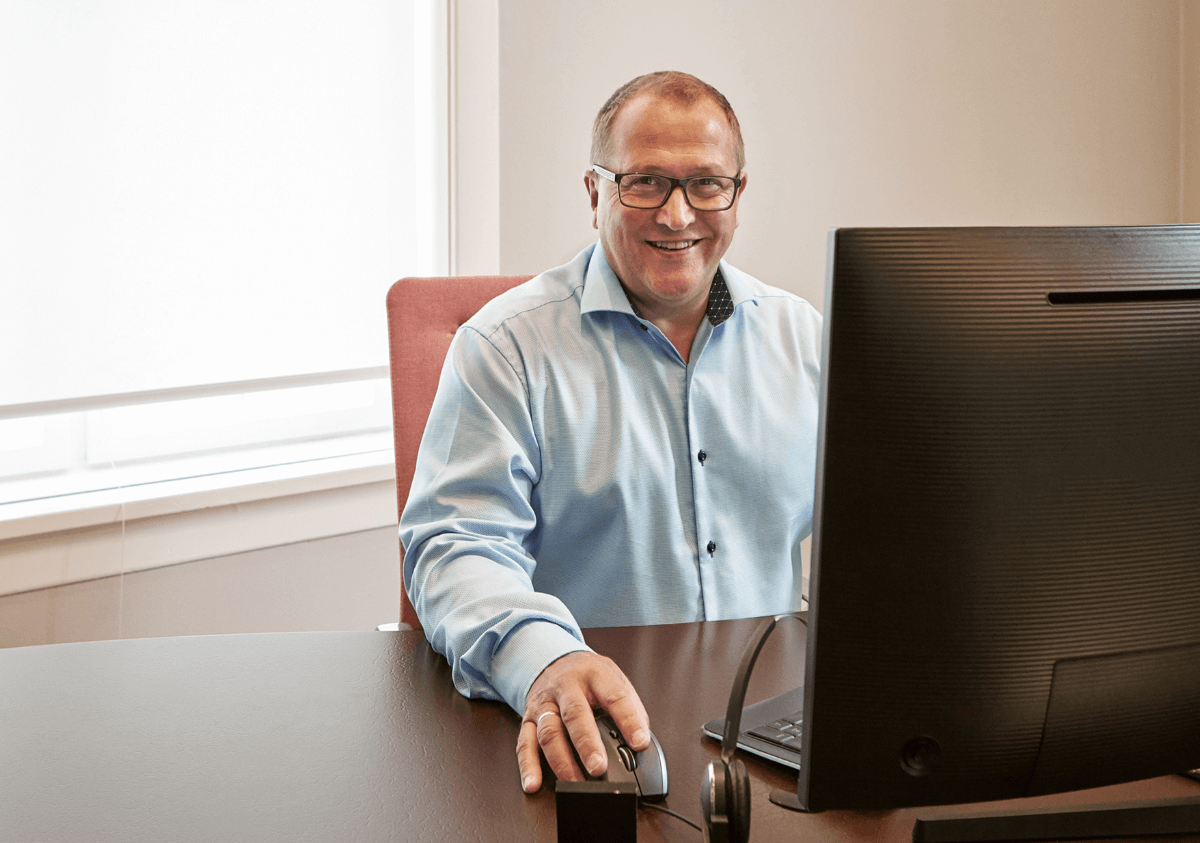 Smiling man sitting in front of his computer in the office