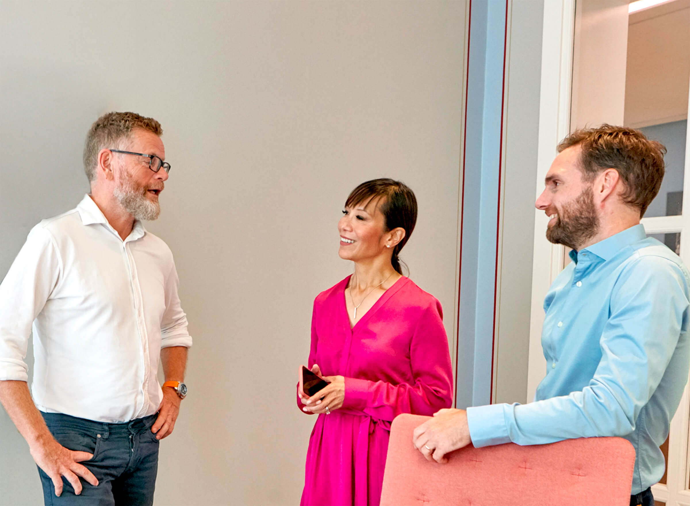 3 colleagues standing in the office having a chat